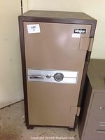 Closed tan Major safe showing combination dial and hinge side