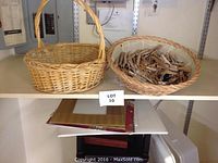 Photo shows two woven baskets on a shelf, one containing wooden clothespins, with paper goods stored underneath