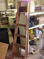 5-foot wooden step ladder with metal bracket reinforcement, showing worn condition