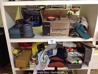 Shelf with assorted skeet targets, fishing and hunting gear including box of skeet targets and caps