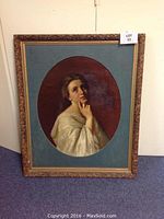 Front view of vintage oil portrait painting of a woman in white and ornate carved gold frame.