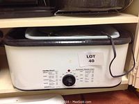 Hamilton Beach Automatic Roaster Oven cream-colored with black trim, dial control, and power cord attached.