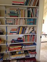 Books and vintage board games stacked on shelves in a doorway