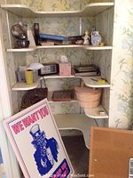 Photo showing shelves with vintage clock, oil lamp, Uncle Sam poster, baskets, checkerboard, and decorative boxes and figurines.