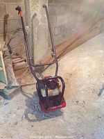 Full view of Honda 4-stroke tiller showing handlebar, fuel tank, and base with rotary tines