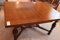 Full view of rectangular table top and four turned legs