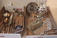 Overall view of silverplate utensils, sugar bowl and accessories in box