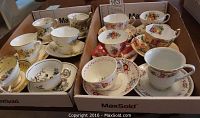 Photo showing 12 tea cups with matching saucers, floral designs ranging in color and detail, vintage brands.