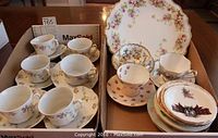 6 white tea cups and saucers with floral designs and gold trim, 3 additional cups and saucers and assorted plates including a cake plate