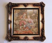 Full view of the ornate framed tapestry depicting a scene with two figures in a natural setting.