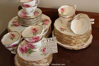 Full lot: stacks of mixed plates and pile of cups and saucers on table