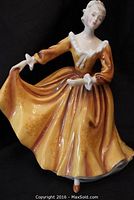 Front view of Royal Doulton porcelain figurine in yellow dress.