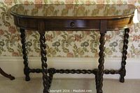 Front view of demi lune table showing twist carved legs and stretcher