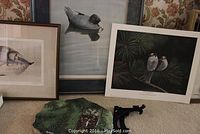 Three framed bird prints shown together, including Paul Martinson 'Whio' and others, plus owl rock and its black wooden stand on carpet
