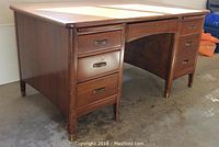 Full front view of desk showing overall structure, drawer layout and closed pull-out shelves