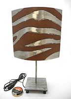 Front view of lamp showing polished zebra stripe design on shade.
