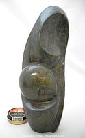 Front view of 'Dreamer' sculpture in serpentine stone showing curved abstract form and spherical detail with smooth polished finish.