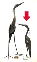 Two steel heron sculptures shown on white background with red arrow marking the 26in piece