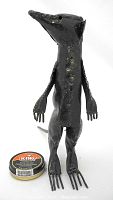 Front view of welded recycled steel meerkat sculpture with tin of shoe polish for scale.