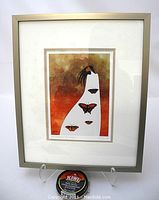 Framed print showing full artwork and frame with stand and kiwi shoe polish can for size reference.