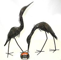 Two heron sculptures side by side with Kiwi shoe polish can for scale