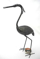Front view of welded metal egret sculpture with slender legs, long neck, and detailed head features.