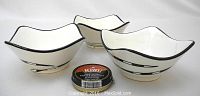 Three Kaiser ceramic bowls with black and white indigenous African tribal motifs, arranged together with shoe polish for scale.
