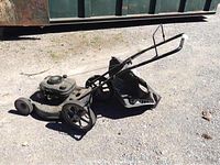 Angled side view of the Craftsman lawn mower showing dark green metal body, wheels, handle, and attached black mulch bag.