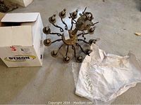 Chandelier laid on floor next to box of prisms