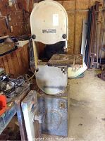 Front view of the Rockwell Model 14 Band Saw on metal stand inside a workshop, showing the full height and front of the machine.