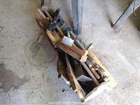 Top view of the wooden toolbox showing interior filled with wood handled hand saws and other tools