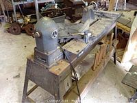 Wide angle view showing the Rockwell lathe mounted on a stand with Craftsman Copy Crafter lathe bed and assorted hand tools.