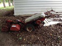 Side view showing full unit layout: front attachment, drive wheels, engine frame and handles.