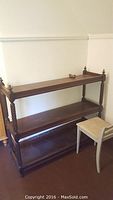 Full view of vintage wood bookshelf with three shelves and the chair beside it