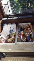 Two boxes showing glassware, Royal Doulton figurines including intact Miss Demure and broken Leading Lady, and other items.