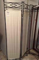 Full view of the three-panel metal screen divider showing two fabric-covered panels and one panel missing fabric.