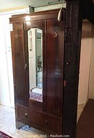Front view of the antique walnut wardrobe showing full-length mirror and bottom drawer