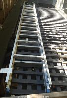 Full view of the aluminum extension ladder extended on a lattice surface showing its length and wear.