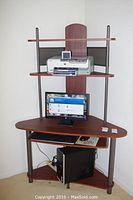 Full view of corner computer desk with monitor, printer, and CPU on shelves (contents not included in sale).