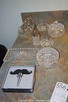 Full view of the glass trinket boxes, dishes, and mustache wine stopper in original box on countertop.
