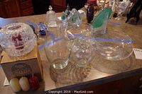 Top view of multiple clear glass bowls, vases and decorative glass items arranged on a table