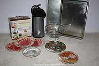 Photo showing all items together: decorative plates, baking sheets, coffee dispenser, and metal fruit basket