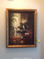 Photo of framed painting hanging on wall, showing full artwork and frame.