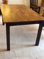 Full view of the rectangular rustic wooden table showing the natural wood grain top and black legs.
