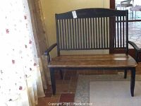 Front view of wooden painted bench showing dark painted frame, armrests, and natural wood seat.