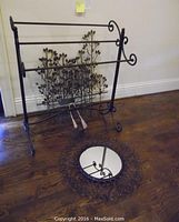 Photo showing metal quilt rack and the round metal framed mirror on floor