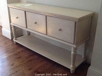 Front view of the filing cabinet showing three drawers and a lower shelf, wooden construction with a light finish.