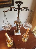 Photo of the full lot showing the ornamental scales with crystal dishes on marble base and two Swedish brass candlesticks with candles.