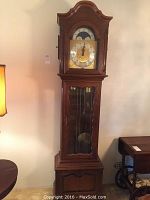 Full frontal view of the tall grandfather clock showing case, bonnet and base