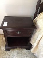 Front view of the mahogany night stand showing drawer and open shelf.